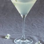 closeup of lemon drop martini on drop cloth surrounded by flowers