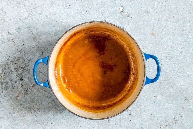 cooked down orange chicken sauce in a blue stock pot