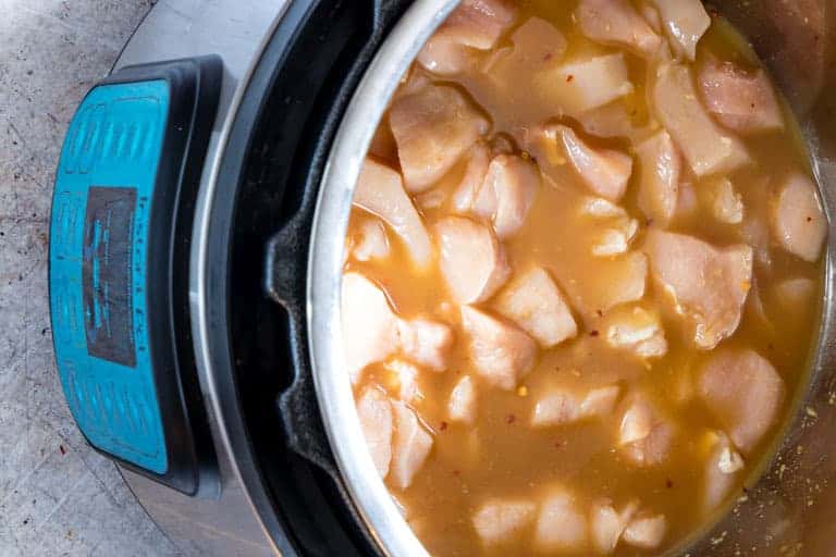 orange chicken inside an instant pot waiting to be cooked