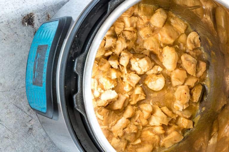 cooked orange chicken in sauce with instant pot lid removed