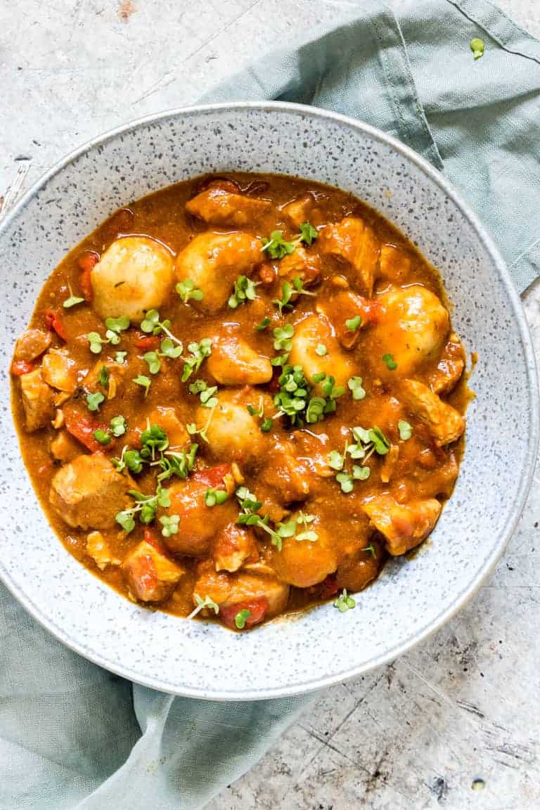close up of a bowl of Caribbean Instant Pot Chicken and Dumplings on a table