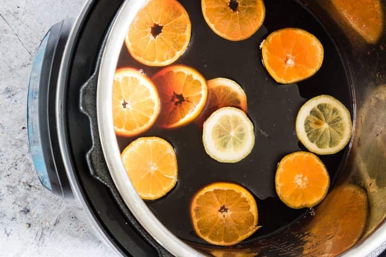 Instant pot full of iced tea and clementines