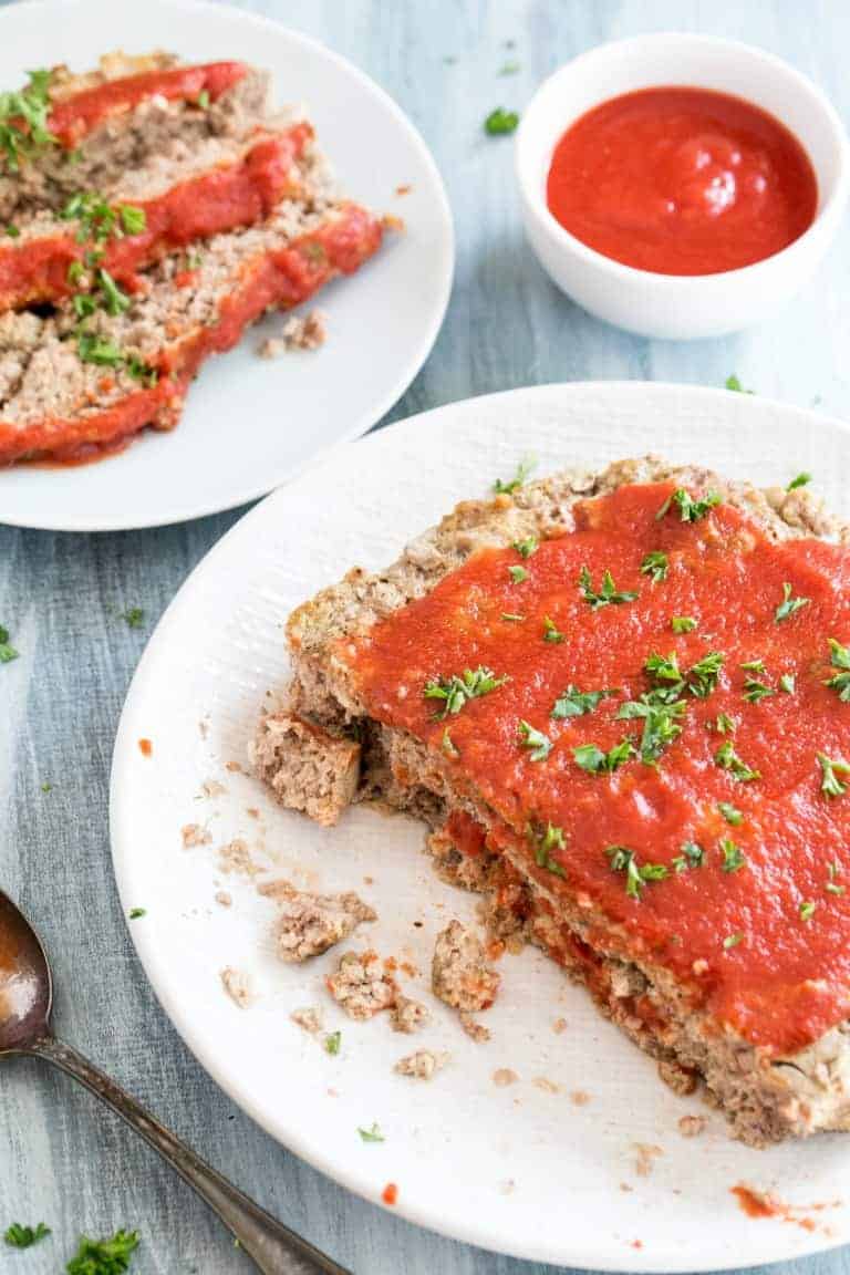 instant pot meatloaf on a white plate in front of sliced meat loaf on a white plate