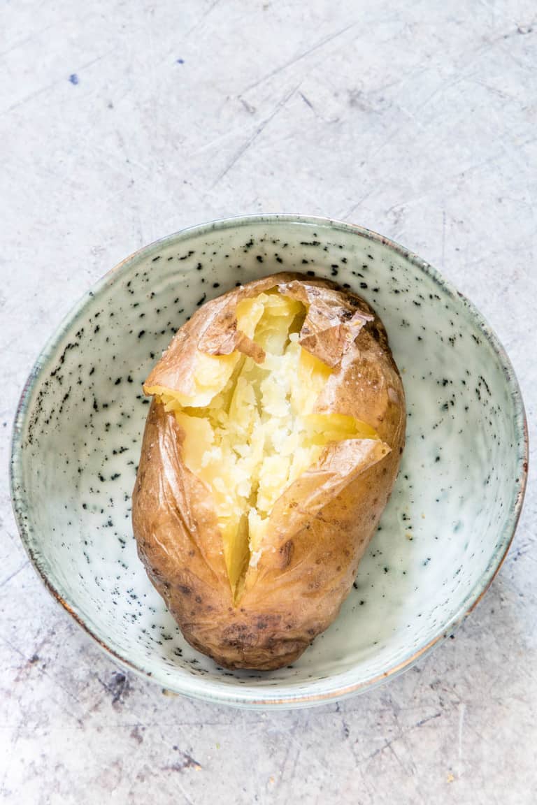 a plan baked potato split, in a bowl