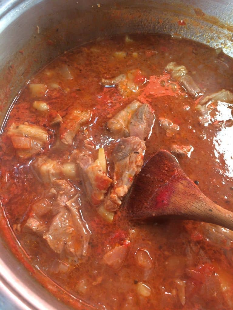 african pepper soup fully cooked with wooden spoon in soup