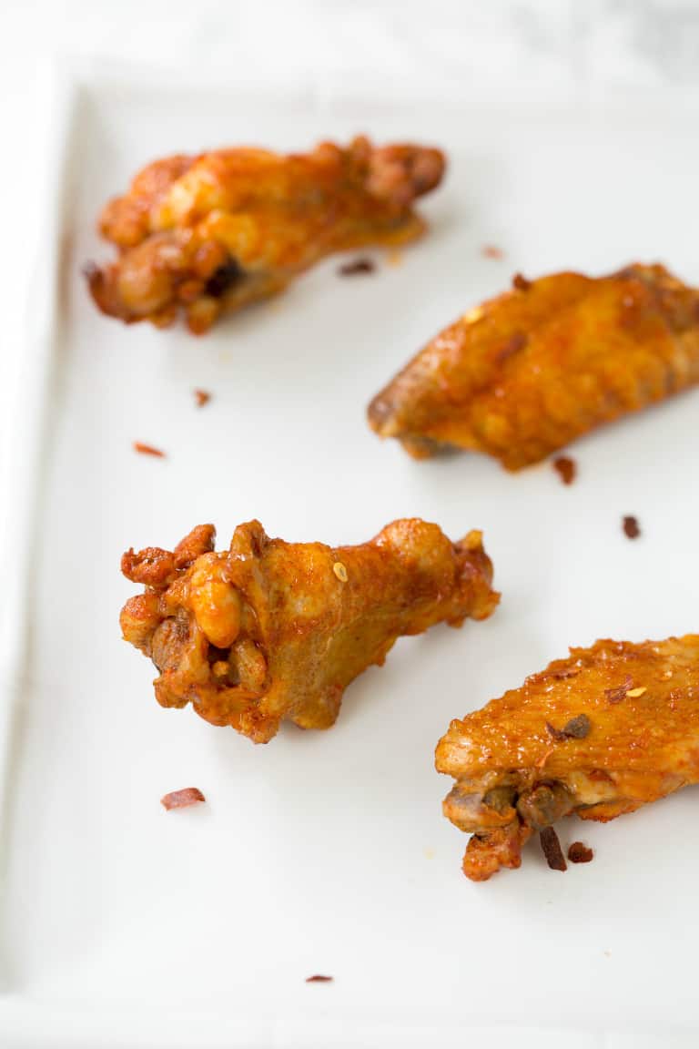 instant pot chicken wings with buffalo sauce on a white plate