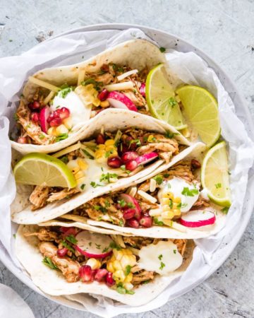 A potrait image of instant pot chicken tacos on a table
