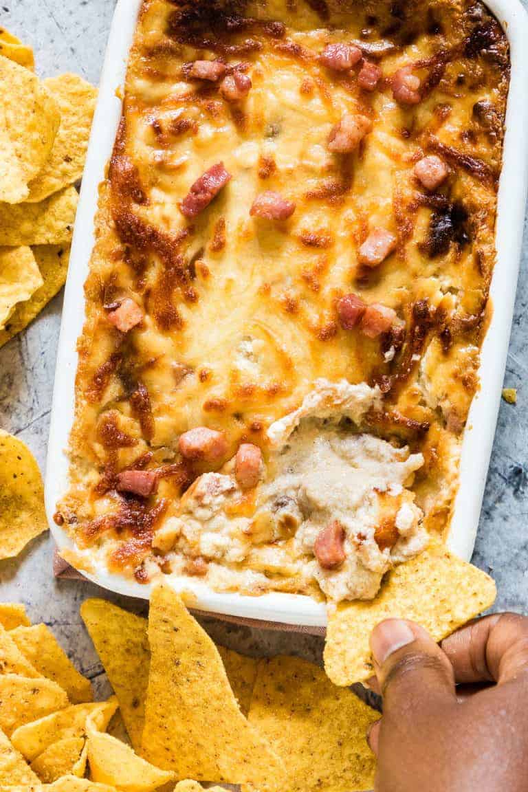 Bacon onion cream cheese dip with tortilla being dipped in
