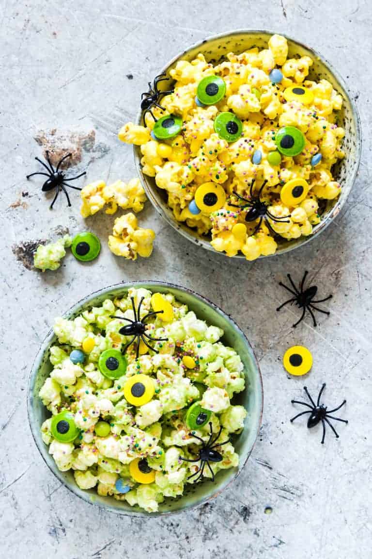 2 bowls of halloween popcorn with spiders and halloween decoration