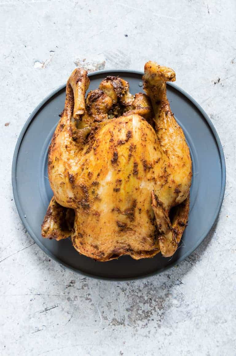 a slow cooker whole chicken on a plate on the kicthen table.