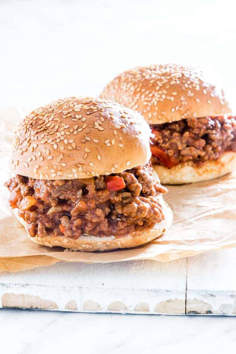 Two completed Instant Pot Sloppy Joes on a piece of parchment paper and ready to serve