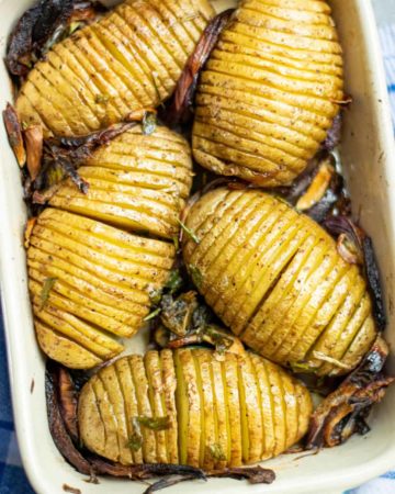 close up of crispy hasselback potatoes in a baking dish