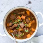 A bowl of instant pot venison stew garnished with herbs