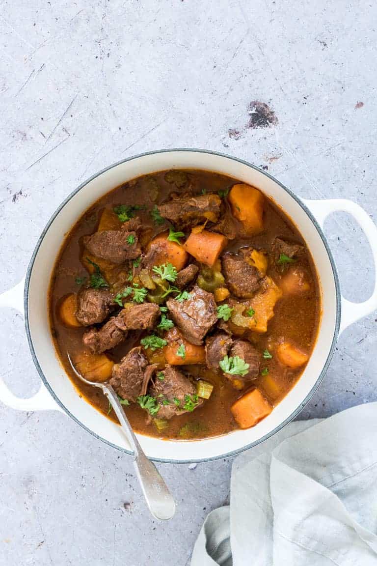 A bowl of instant pot venison stew garnished with herbs