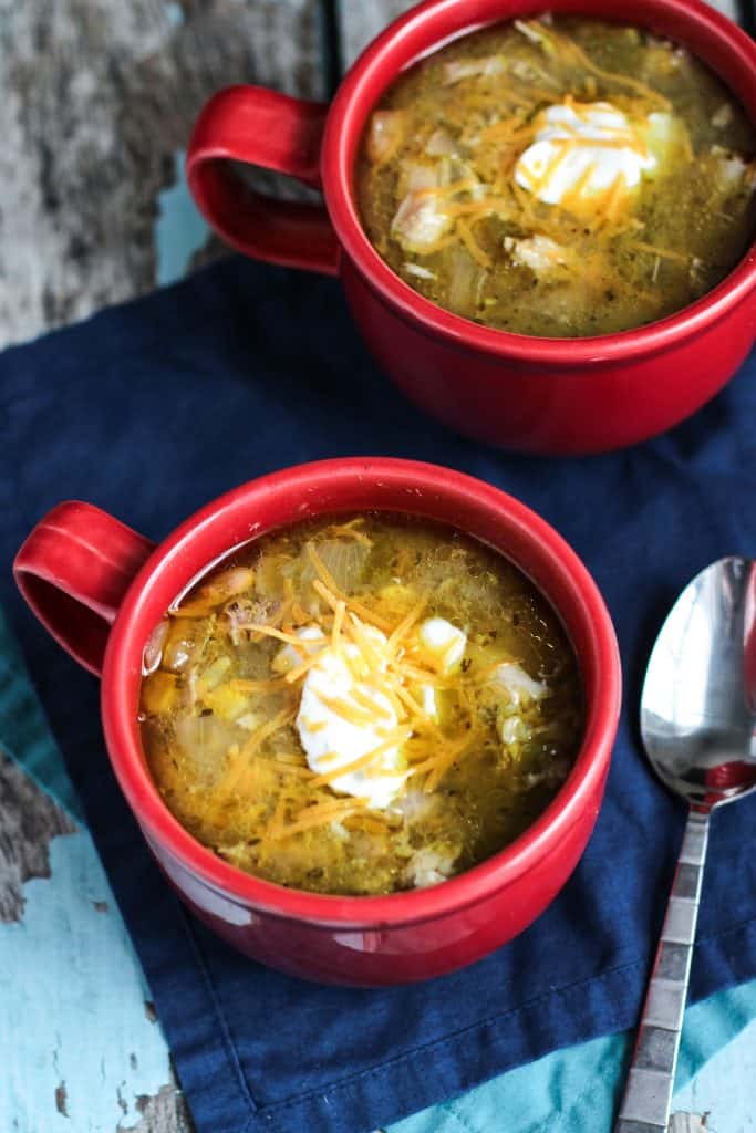 green chicken chili soup served in two red mugs