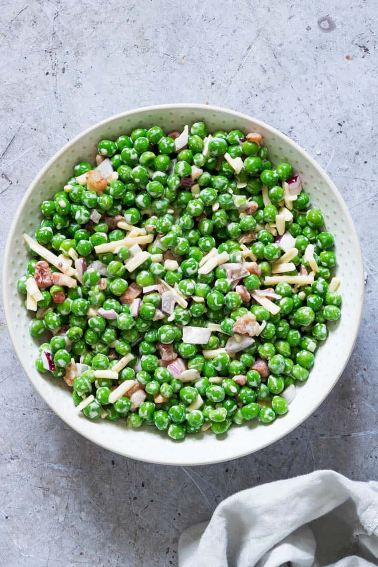 close up view of pea salad in a ceramic bowl