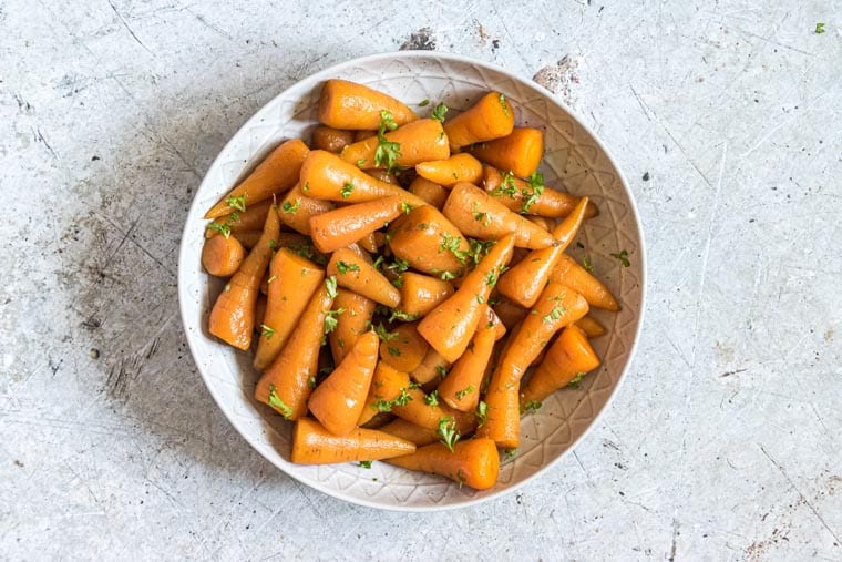 a plate of instant pot glazed carrots garnished with chopped parsley