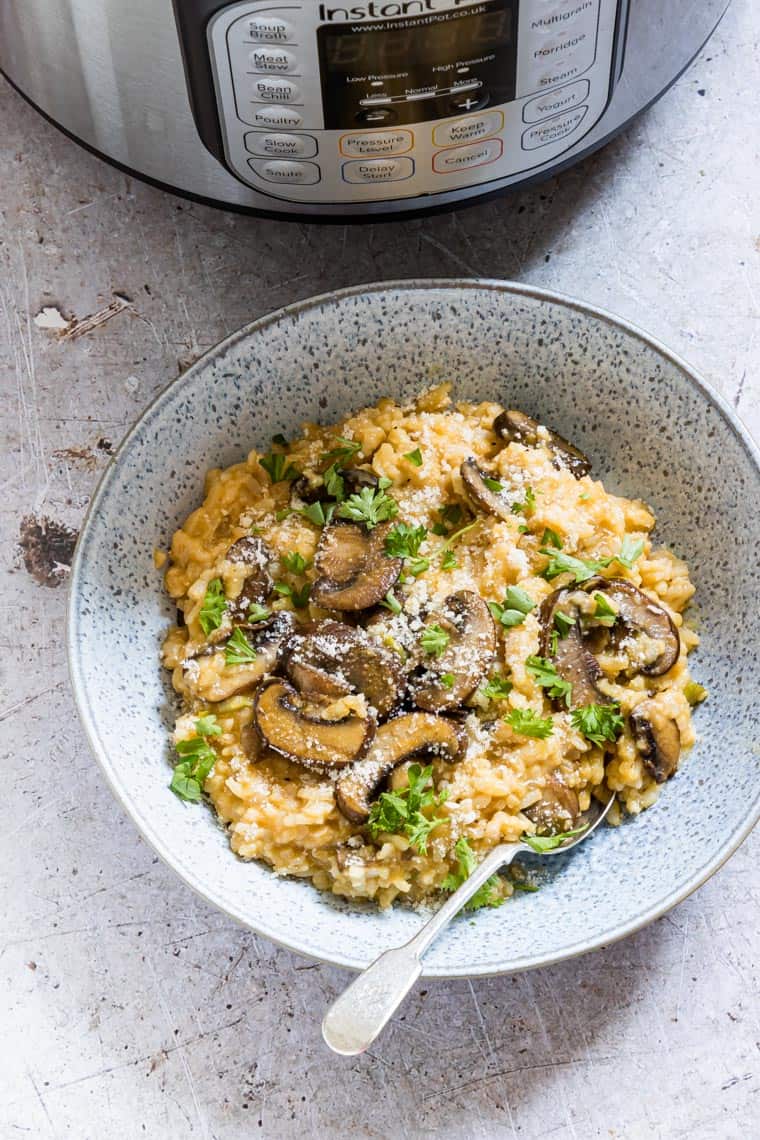 a bowl of instant pot mushroom risotto in front of the instant pot