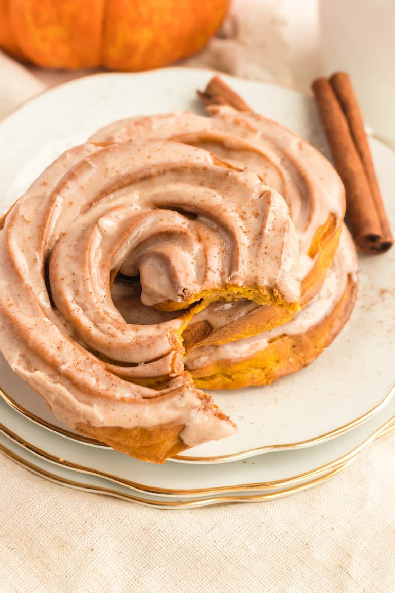 close up of a pumpkin spiced cruller with a bite removed