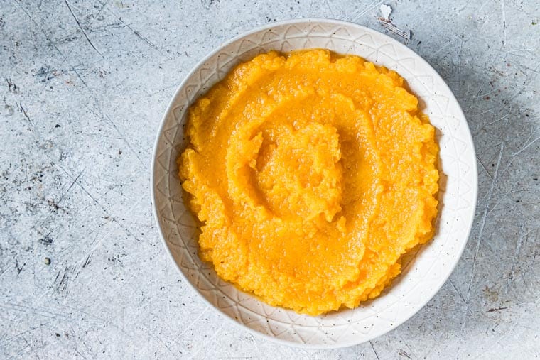 completed pressure cooker mashed butternut squash in a white serving bowl