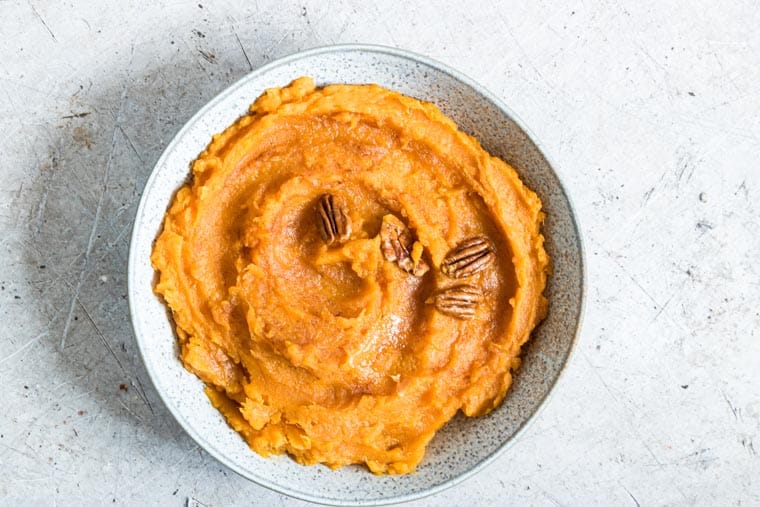 top down view of instant pot mashed sweet potatoes in a ceramic serving dish