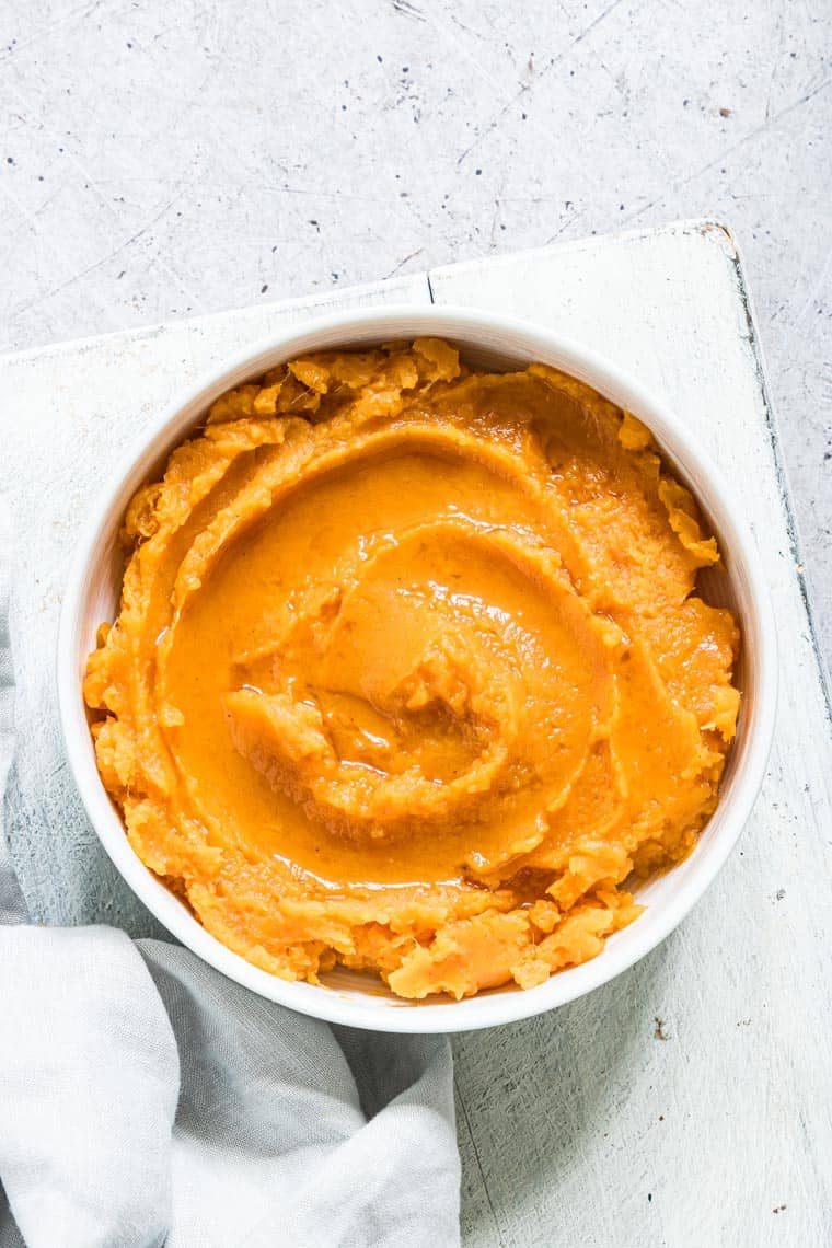 slow cooker sweet potatoes mash served in a white bowl