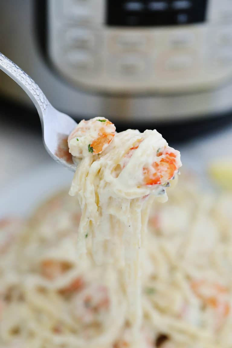 close up view of a forkful of instant pot shrimp alfredo