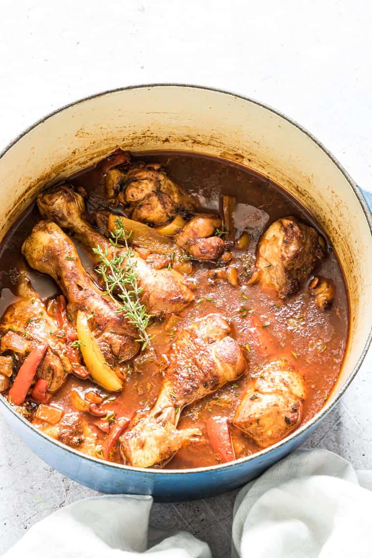 close up view of Jamaican Brown Stew Chicken in a blue cook pot