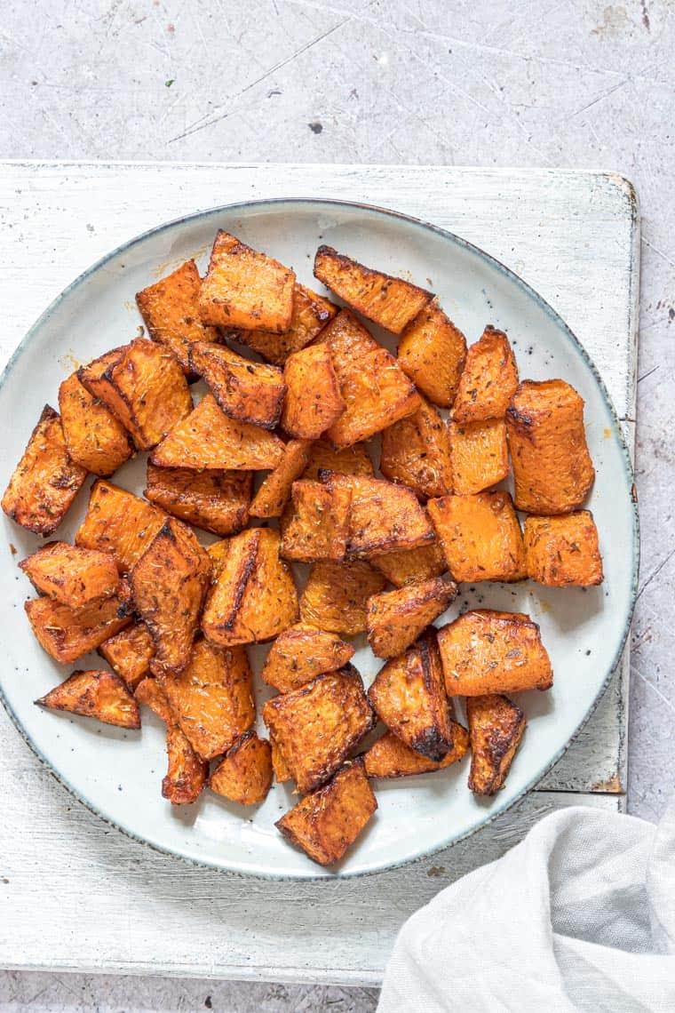 close up of a plate filled with cooked air fryer butternut squash fries