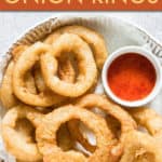 ONION RINGS ON A PLATE WITH A SAUCE ON THE SIDE