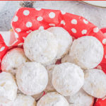 snowball cookies in a basket with polka dot tissue paper.