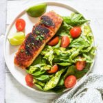easy blackened salmon served on a plate of salad