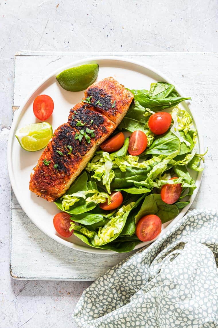 easy blackened salmon served on a plate of salad