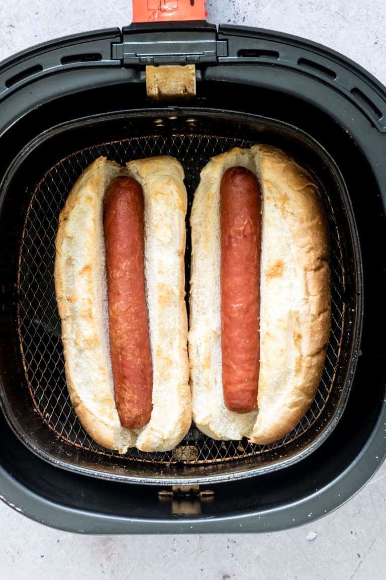 close up view of cooking hot dogs in the air fryer basket