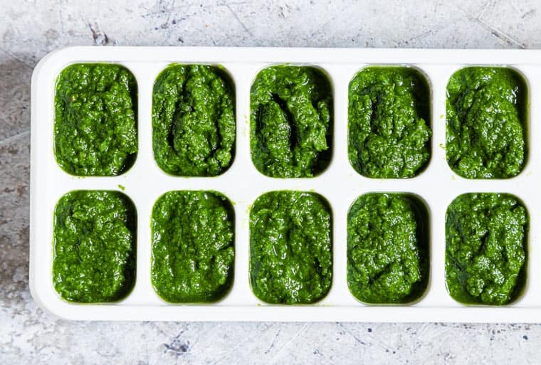 green seasoning inside ice cube tray and ready to be frozen