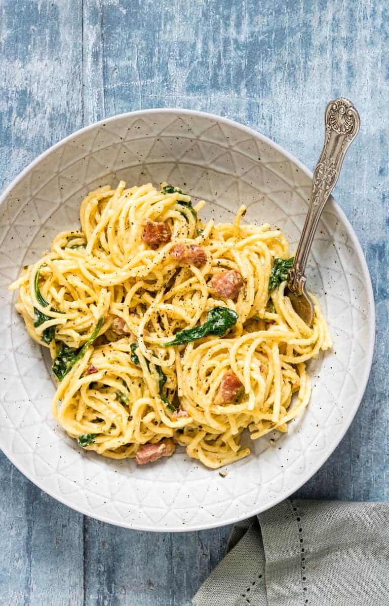 Instant Pot Creamy Bacon Pasta served in a ceramic bowl with a large spoon