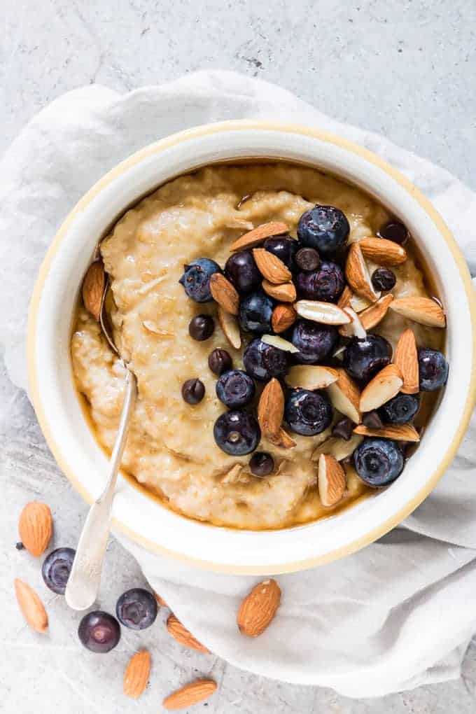 bowl of instant pot steel cut oatmeal topped with blueberries, almonds, and chocolate chips