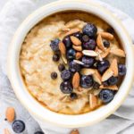 overhead view of bowl of instant pot steel cut oats in white bowl with blueberries and almonds