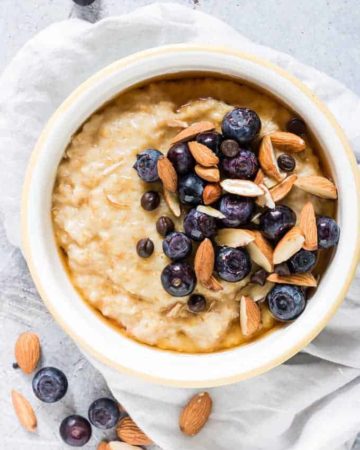 overhead view of bowl of instant pot steel cut oats in white bowl with blueberries and almonds