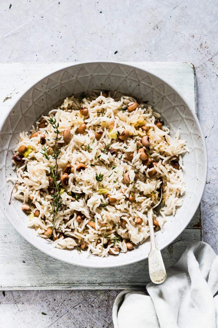 jamaican rice and peas in a ceramic serving dish with spoon