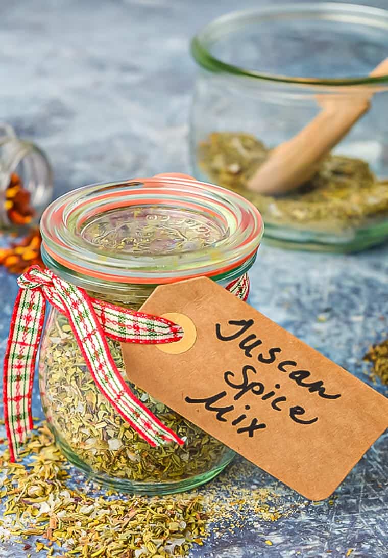 A jar of homemade tuscan seasoning on a tabke with a gift label