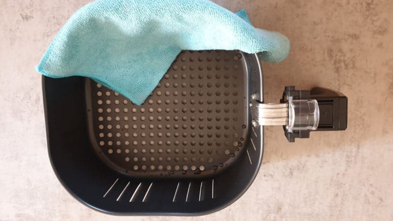cleaning an air fryer basket with microfiber cloth