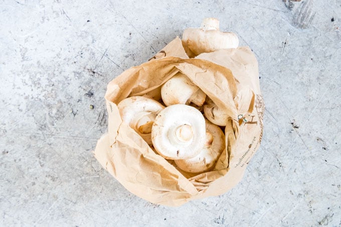fresh white mushrooms inside brown paper to be used in mushroom masala