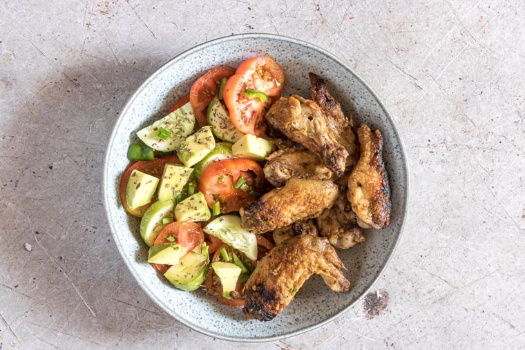 smoked wings in a bowl with salad