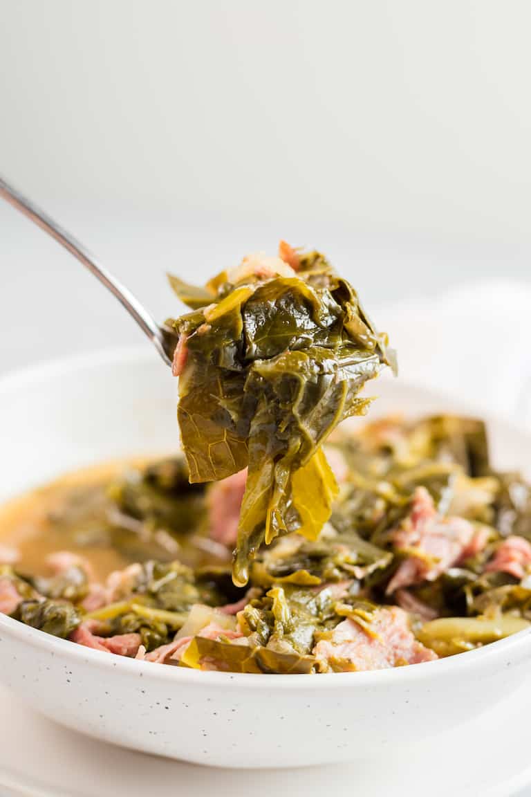 close up view of a spoonful of instant pot collard greens