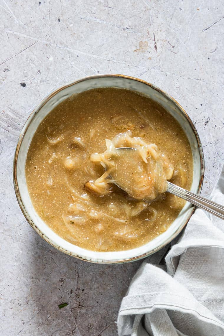 a bowl of homemade gravy with a spoon inside