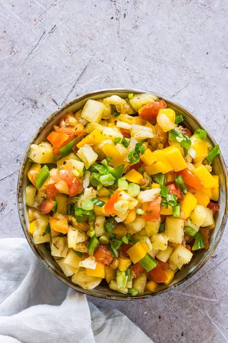 a brown serving bowl filled with mango pineapple salsa
