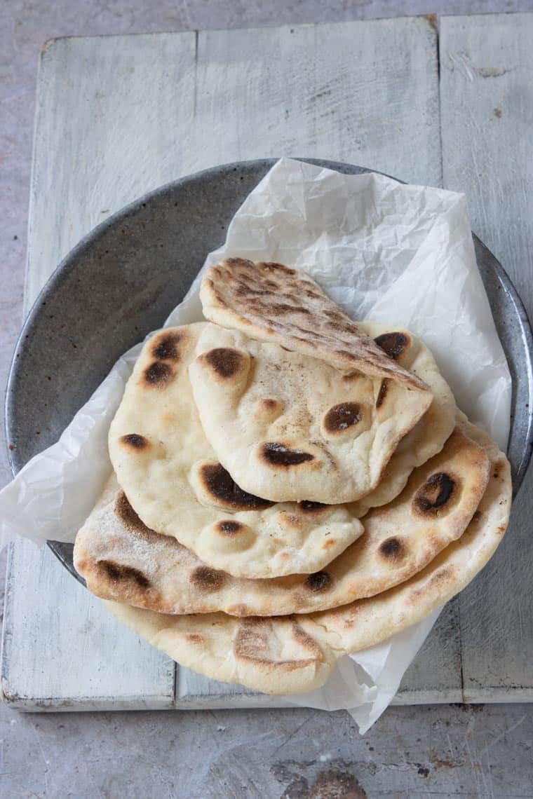 cooked flatbreads served on a cloth napkin inside a in a dish