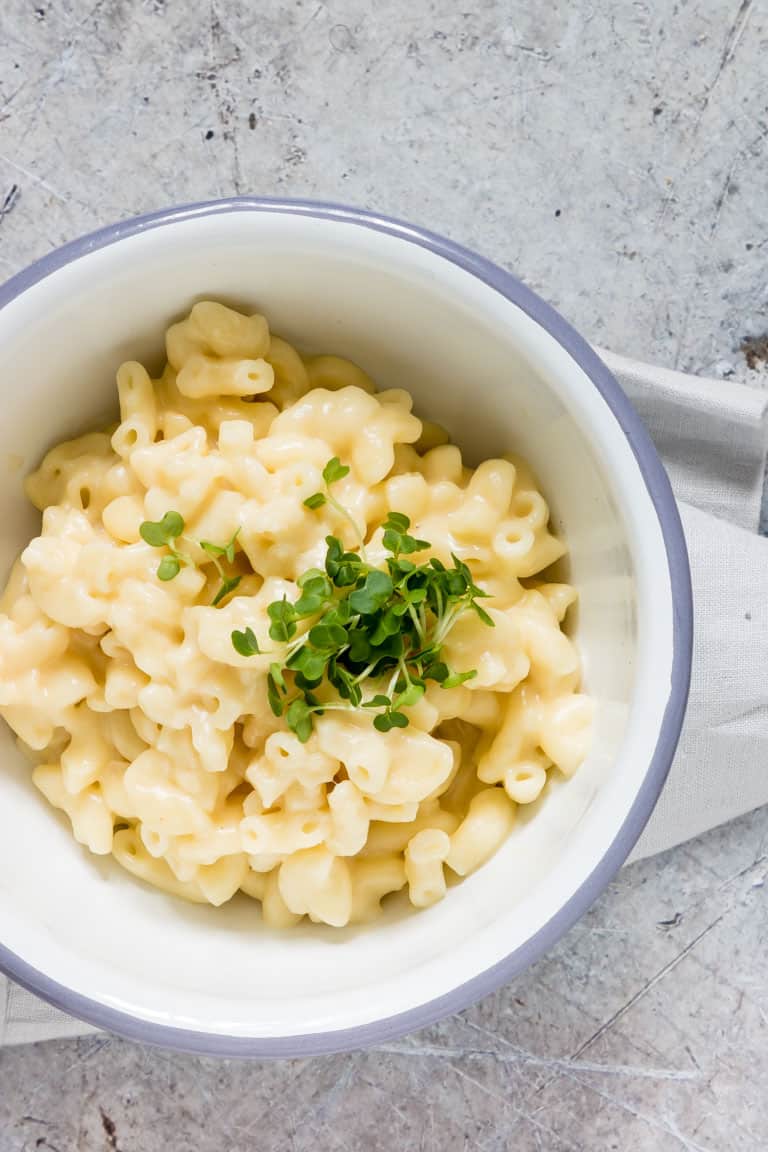 white bowl with blue rim containing evaporated milk instant pot mac and cheese