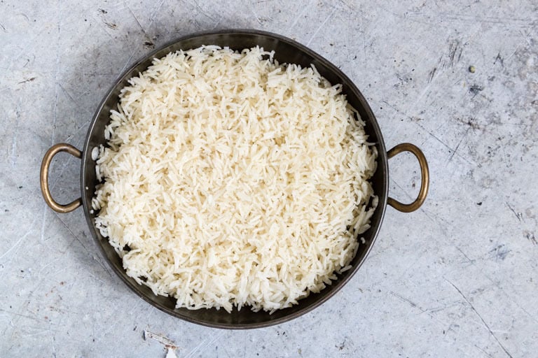large black pot containing instant pot rice on a blue background